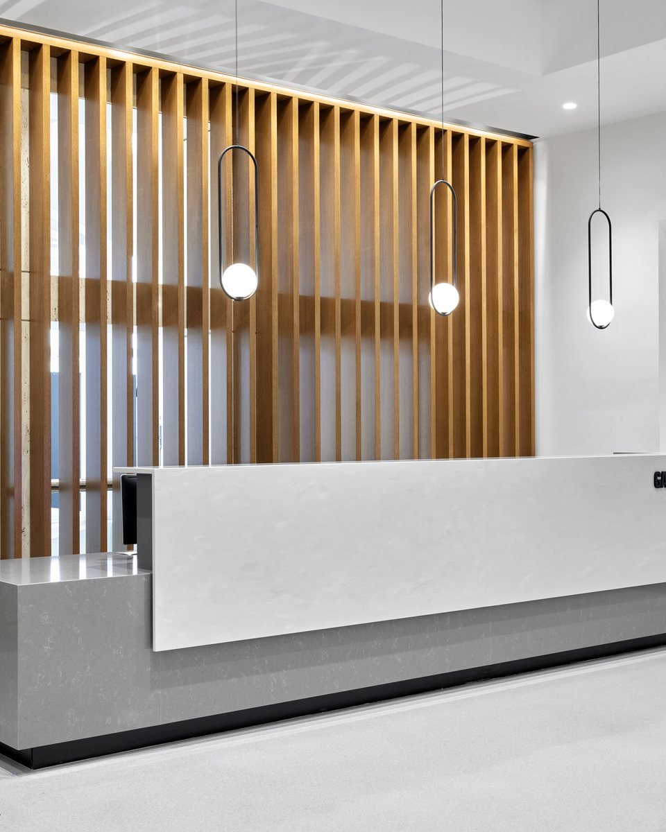 Slat-wood reception wall and stone reception desk